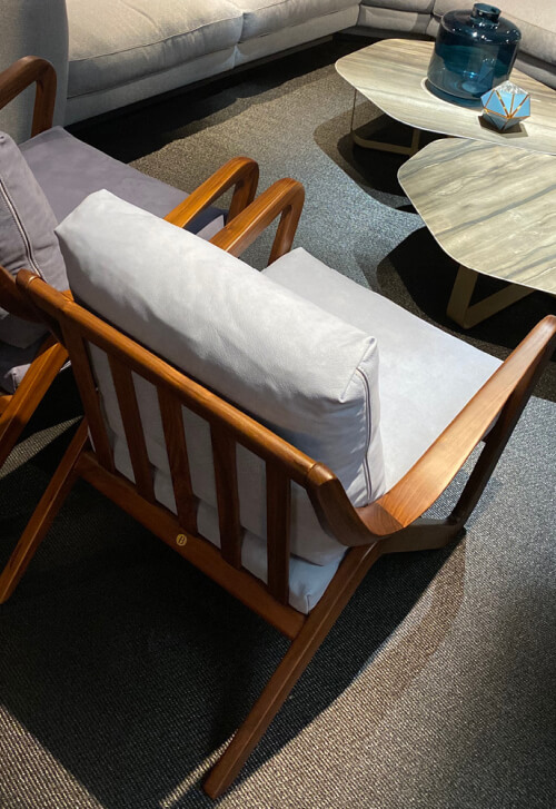 Borzalino Taylor armchair – walnut frame with light grey cushions in a showroom